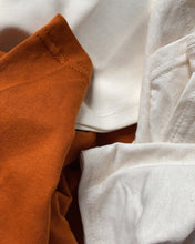 Load image into Gallery viewer, Close up of terracotta autumn orange tshirt and natural tshirt 
